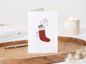 Minimalist modern Christmas card with illustrated gift in a Christmas sock elemente design