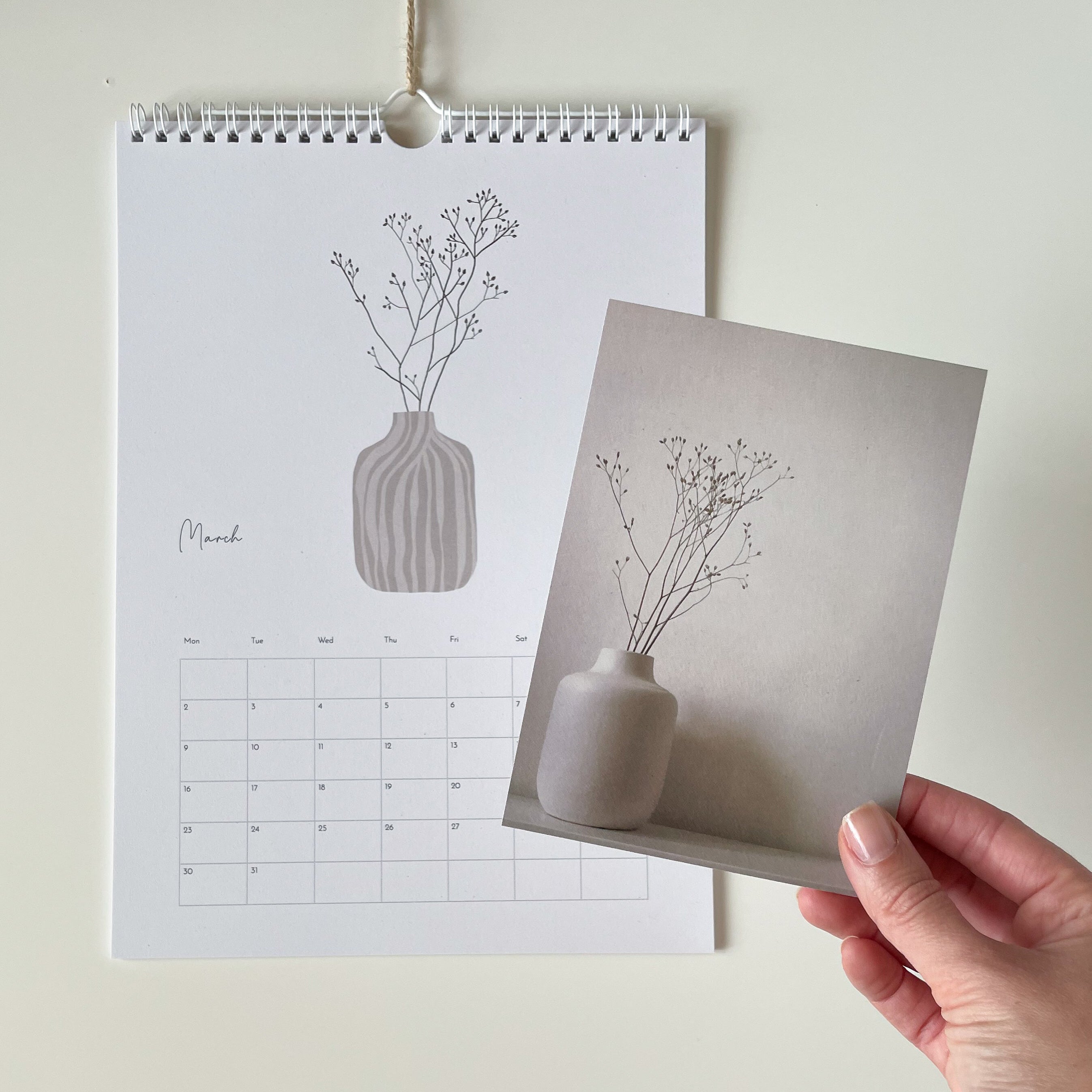 Calendar with a vase and plant design, held by a hand