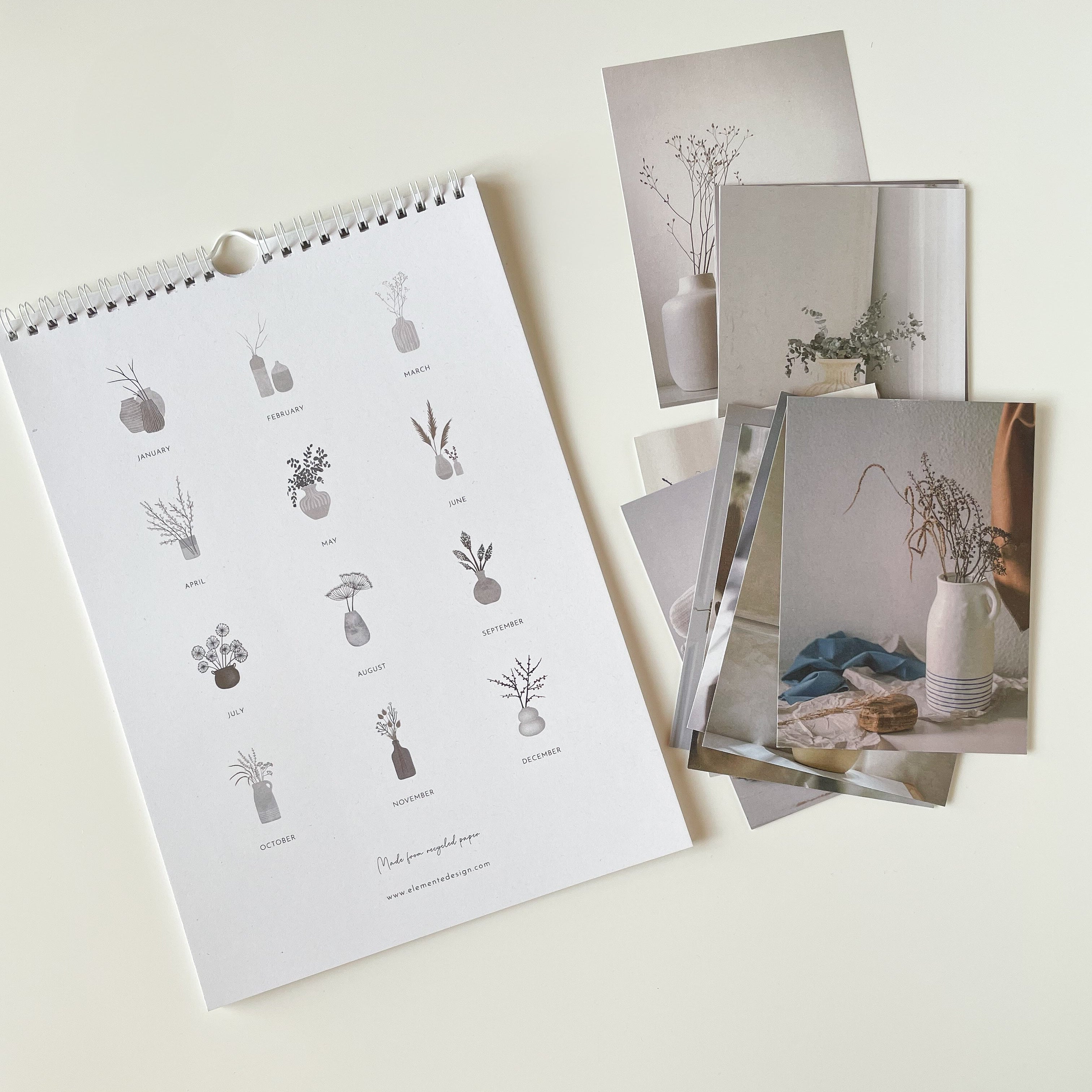 Set of postcards and a spiral-bound calendar with botanic in vase illustrations on a light background